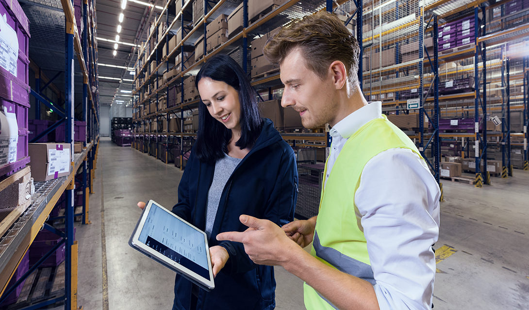 Digital logistics woman and man using a tablet in the warehouse